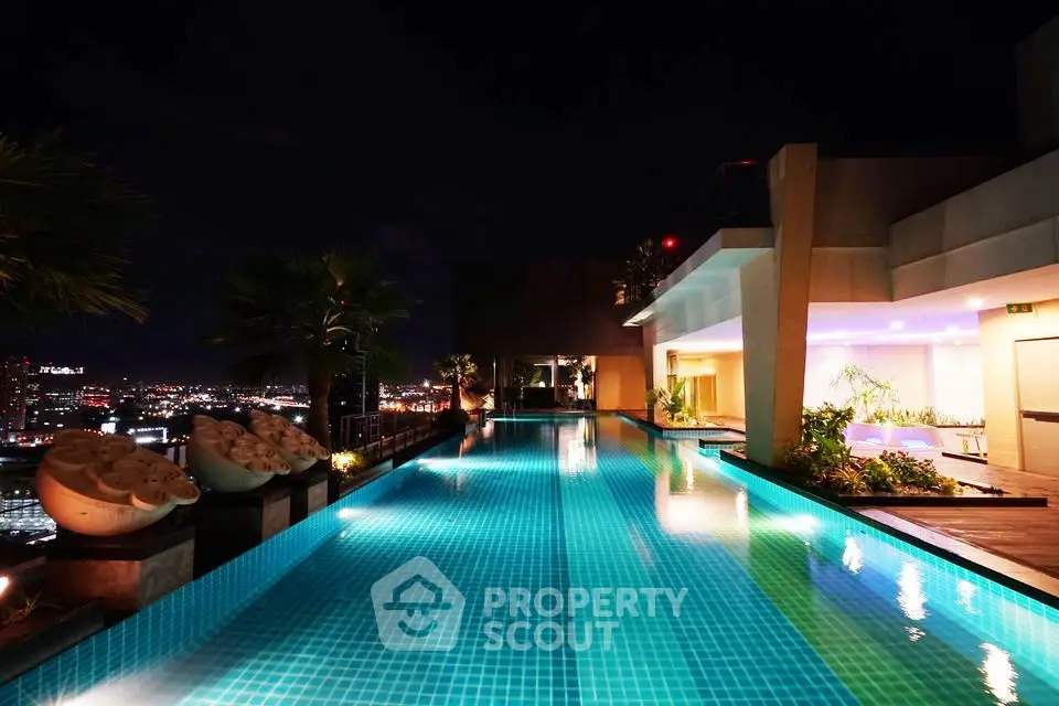Luxurious rooftop pool with stunning city night view, perfect for relaxation and entertainment.