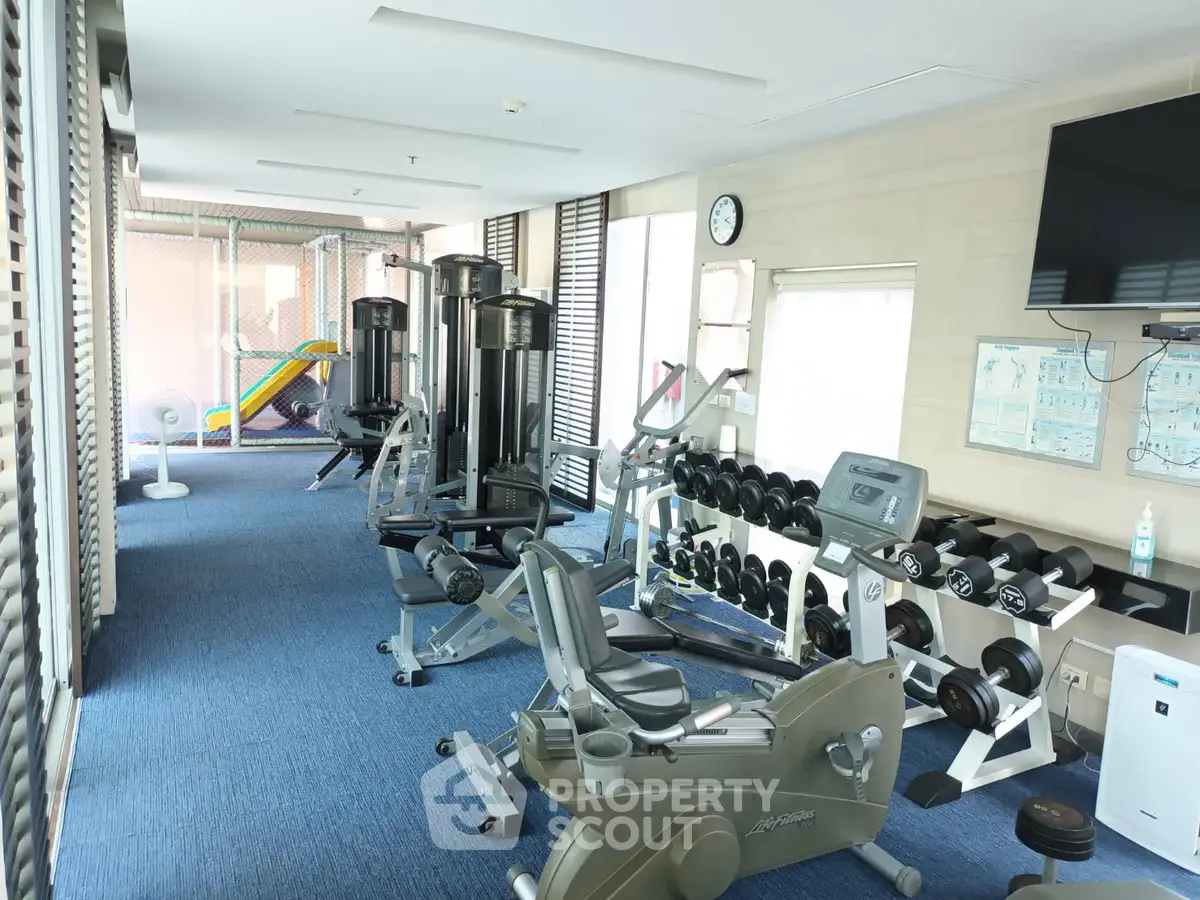 Modern gym with exercise equipment and bright interior in a real estate property.
