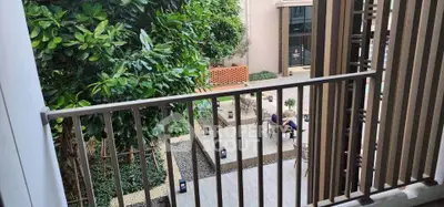 Charming balcony view overlooking lush garden in modern residential complex.