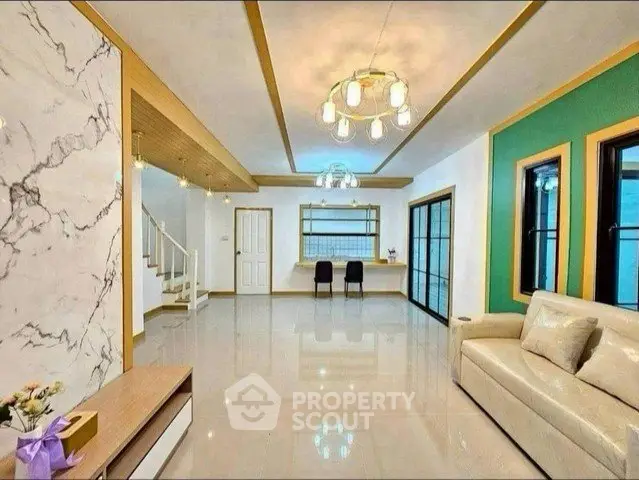 Spacious modern living room with elegant lighting and marble accents, perfect for stylish living.