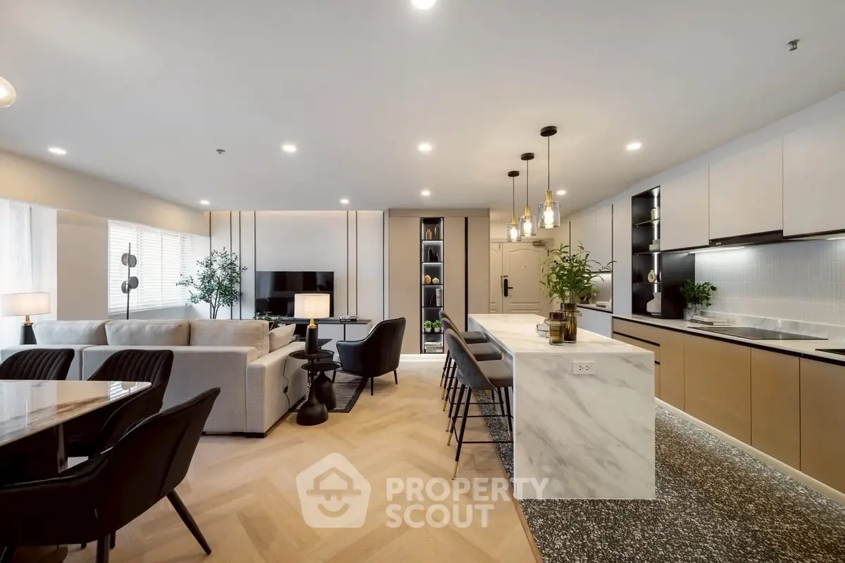 Luxurious open-plan living room and kitchen with modern furnishings and elegant lighting.
