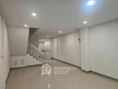 Spacious modern living room with sleek staircase and tiled flooring