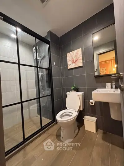 Modern bathroom with sleek design, featuring a glass-enclosed shower and stylish fixtures.