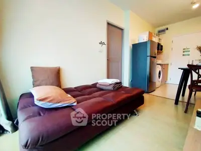 Cozy living room with modern furniture and compact kitchen in open layout apartment.