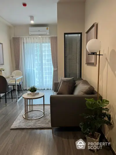 Modern living room with stylish decor and natural light, featuring a cozy sofa and elegant dining area.