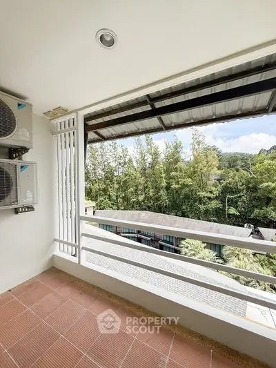 Spacious balcony with scenic view of lush greenery and modern air conditioning units.