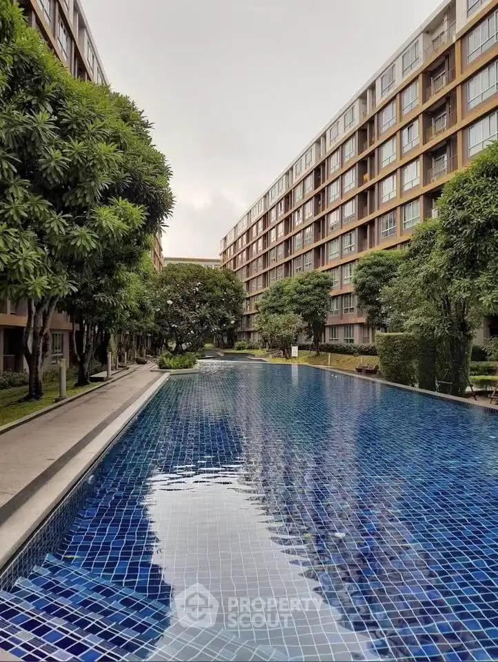 Luxurious residential building with a stunning outdoor pool and lush greenery.