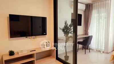 Modern living room with sleek TV setup and cozy study nook by the window.