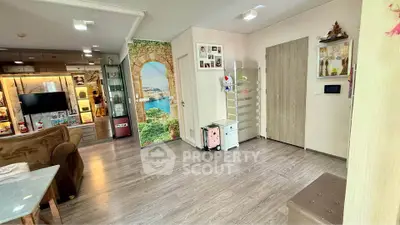 Spacious living room with modern decor and wooden flooring, featuring a scenic wall mural and ample storage.