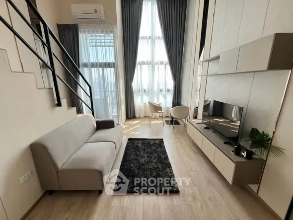 Modern loft-style living room with high ceilings and large windows, featuring sleek furniture and natural light.