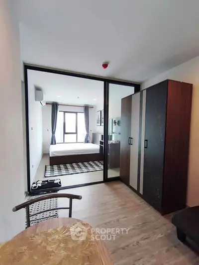 Modern apartment interior with glass partition, cozy bedroom, and stylish decor