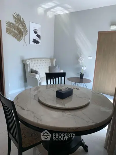 Charming dining area with elegant marble table and cozy seating in a stylish home interior.