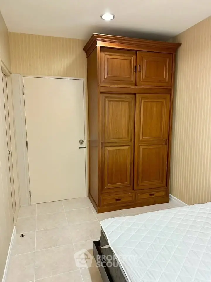 Cozy bedroom with wooden wardrobe and comfortable bed in modern apartment.