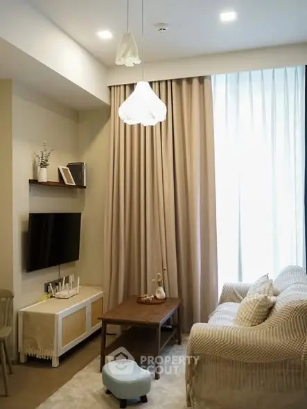 Cozy living room with modern decor, soft lighting, and elegant curtains.