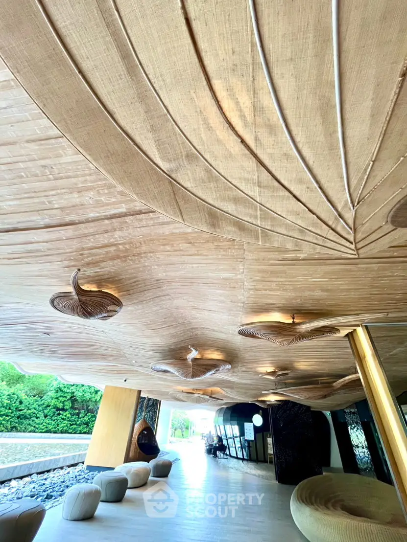 Luxurious modern building entrance with artistic ceiling design and elegant seating area.