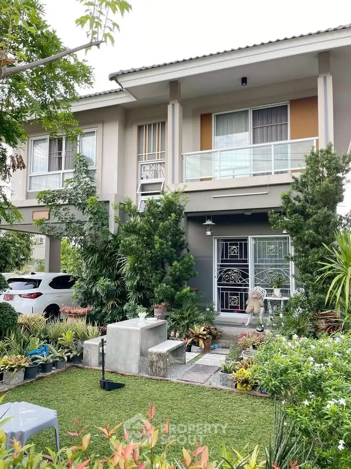 Charming two-story house with lush garden and modern facade