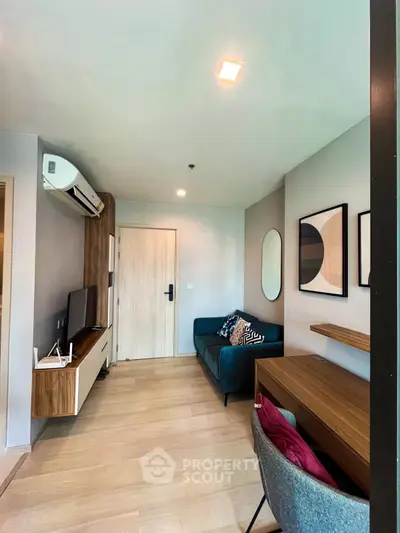 Modern living room with stylish decor and wooden flooring, featuring a cozy sofa and wall-mounted TV.