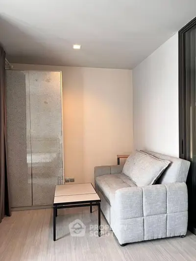 Modern living room with sleek gray sofa and minimalist decor, perfect for urban living.