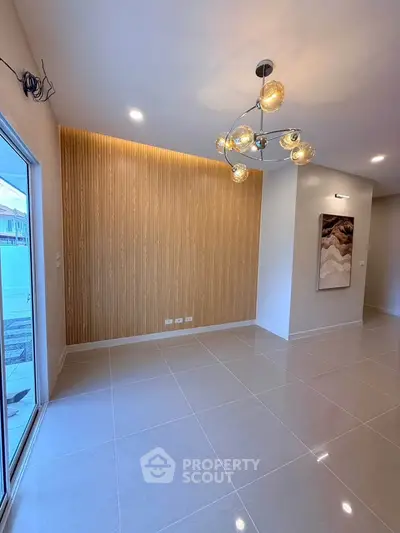 Modern living room with stylish lighting and wooden accent wall, perfect for contemporary living.
