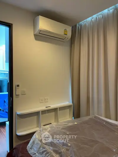 Modern bedroom with air conditioning and elegant curtains, perfect for comfortable living.