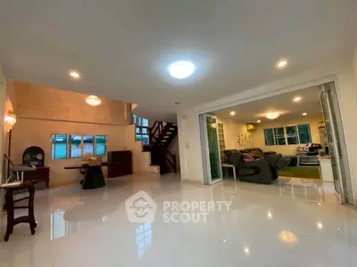 Spacious open-plan living room with modern furnishings and elegant lighting in a stylish home.