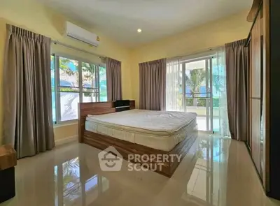 Spacious bedroom with large windows and balcony access, offering serene views and abundant natural light.