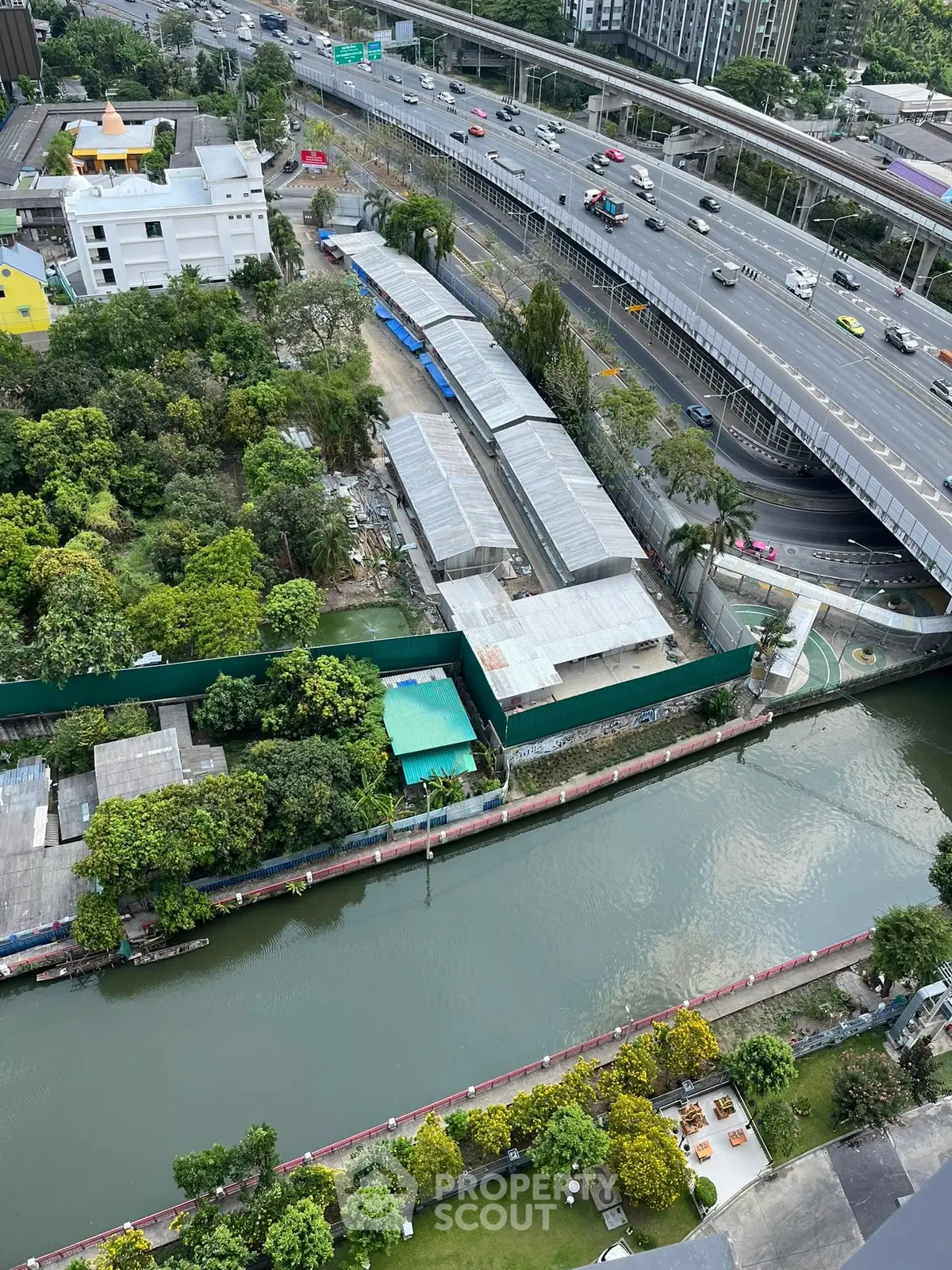 Stunning aerial view of urban landscape with lush greenery and river, perfect for real estate investment.