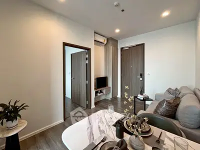 Modern living room with stylish decor and open layout, featuring a cozy sofa and elegant dining area.