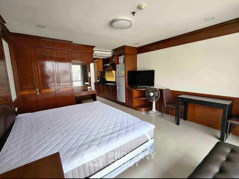 Spacious studio apartment with modern furnishings and open kitchen layout.
