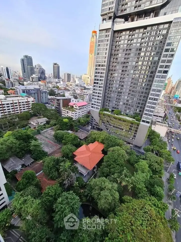 Stunning cityscape view from high-rise building with lush greenery and modern architecture.