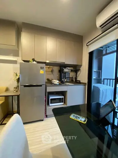 Modern kitchen with sleek appliances and balcony view in stylish apartment