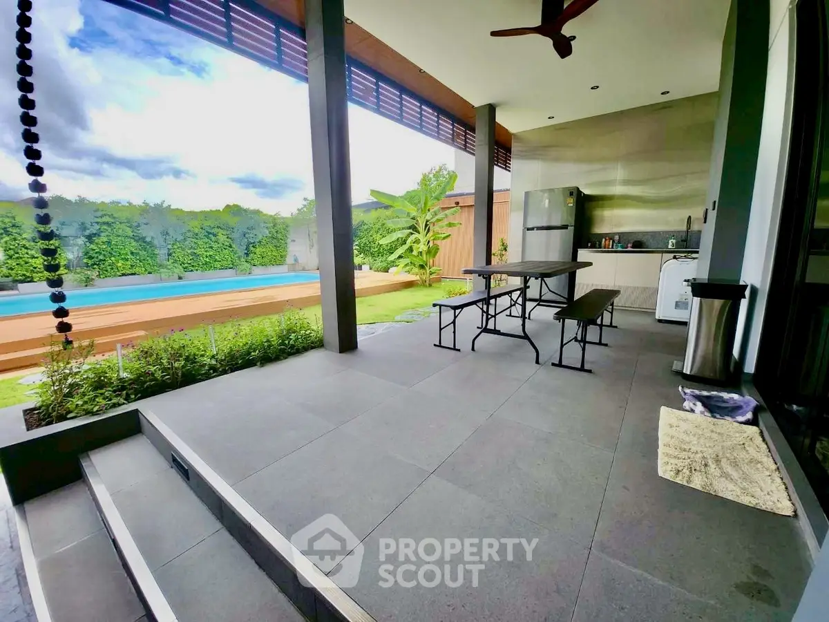 Luxurious outdoor patio with poolside view and modern kitchen amenities