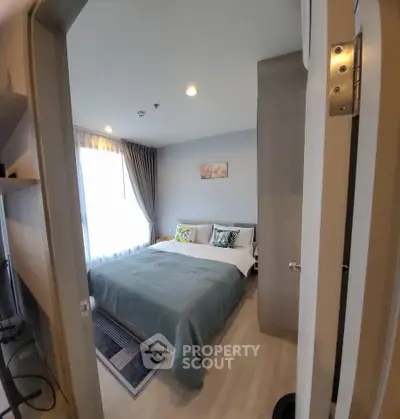 Cozy bedroom with modern decor and ample natural light, perfect for relaxation and comfort.