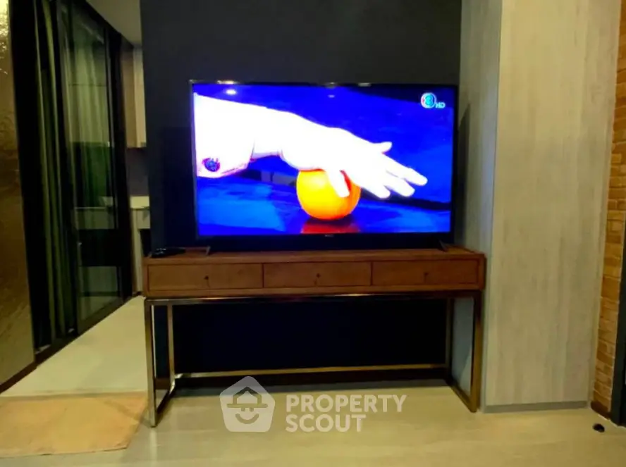 Modern living room with sleek TV stand and large flat-screen TV, perfect for entertainment.