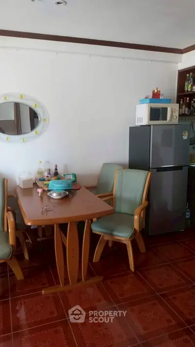 Cozy dining area with wooden table, chairs, and modern appliances in a well-lit kitchen space.