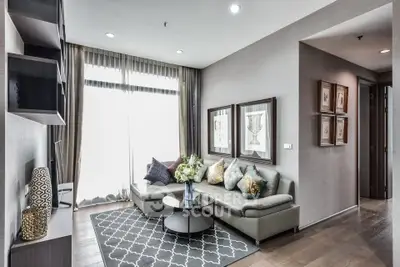 Modern living room with stylish decor, large windows, and comfortable seating in a contemporary apartment.