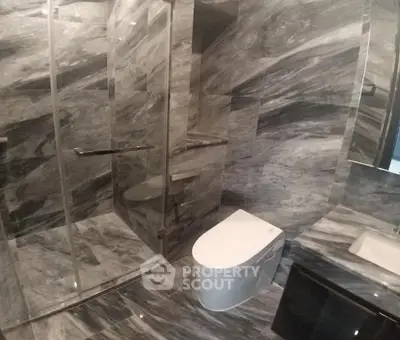 Luxurious marble bathroom with modern fixtures and glass shower enclosure