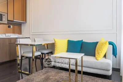 Modern living room with stylish furniture and vibrant cushions in a cozy apartment setting.