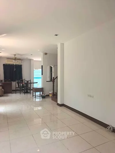 Spacious open-plan living room with modern decor and abundant natural light.