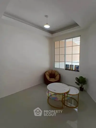 Minimalist living room with cozy chair and modern coffee table, perfect for relaxation.