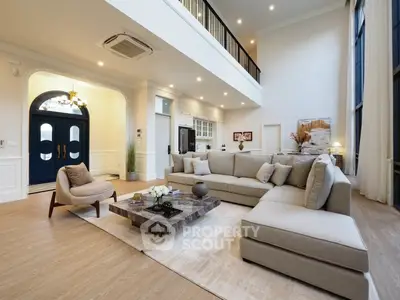 Luxurious double-height living room with elegant decor and spacious seating area.