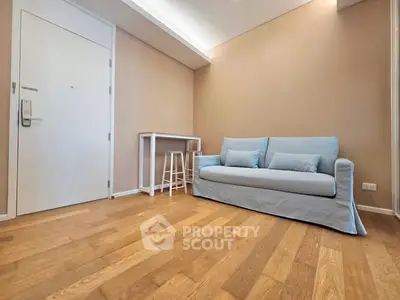 Cozy living room with light blue sofa and wooden flooring, perfect for relaxation.