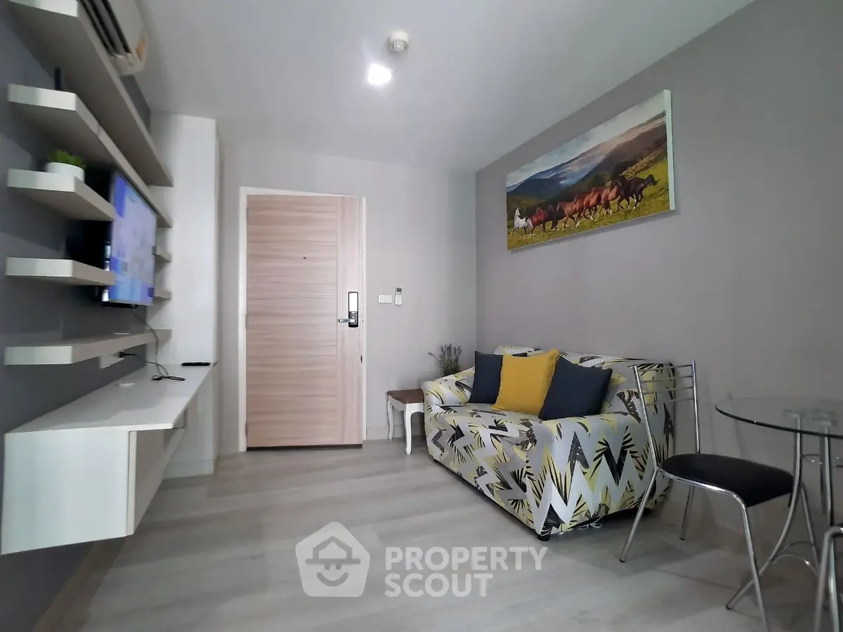 Modern living room with stylish decor and wall art, featuring a cozy sofa and sleek shelving.