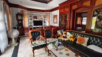 Elegant living room with classic wooden furniture and plush toys, perfect for family gatherings.