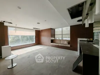 Spacious living room with large windows and built-in seating, ideal for modern living.