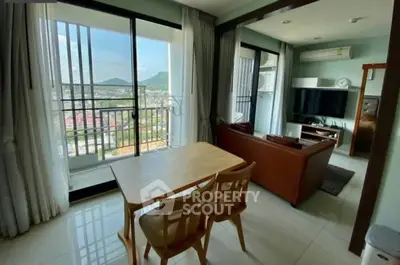 Spacious living room with balcony and stunning city view, featuring modern furniture and natural light.