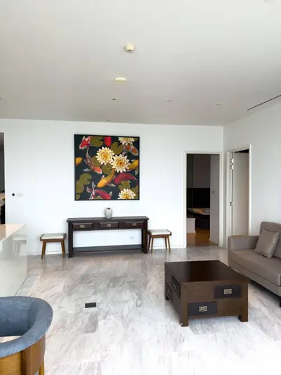 Spacious living room with elegant decor and modern furniture, featuring a vibrant floral painting.