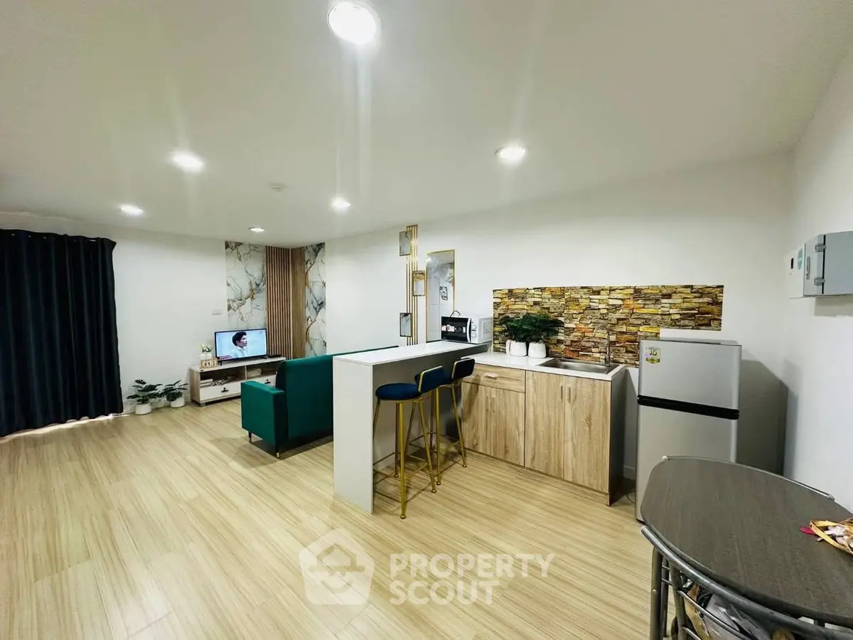 Modern open-layout living room with stylish kitchen and cozy seating area