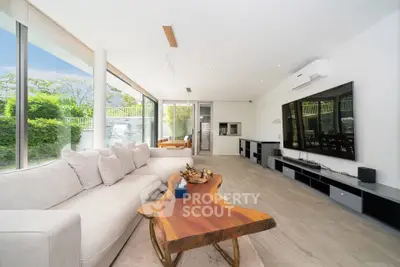 Spacious modern living room with large windows and stylish wooden table