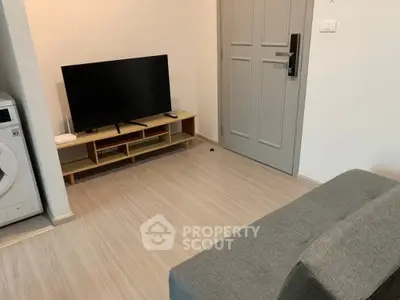 Cozy living room with modern TV setup and washing machine corner